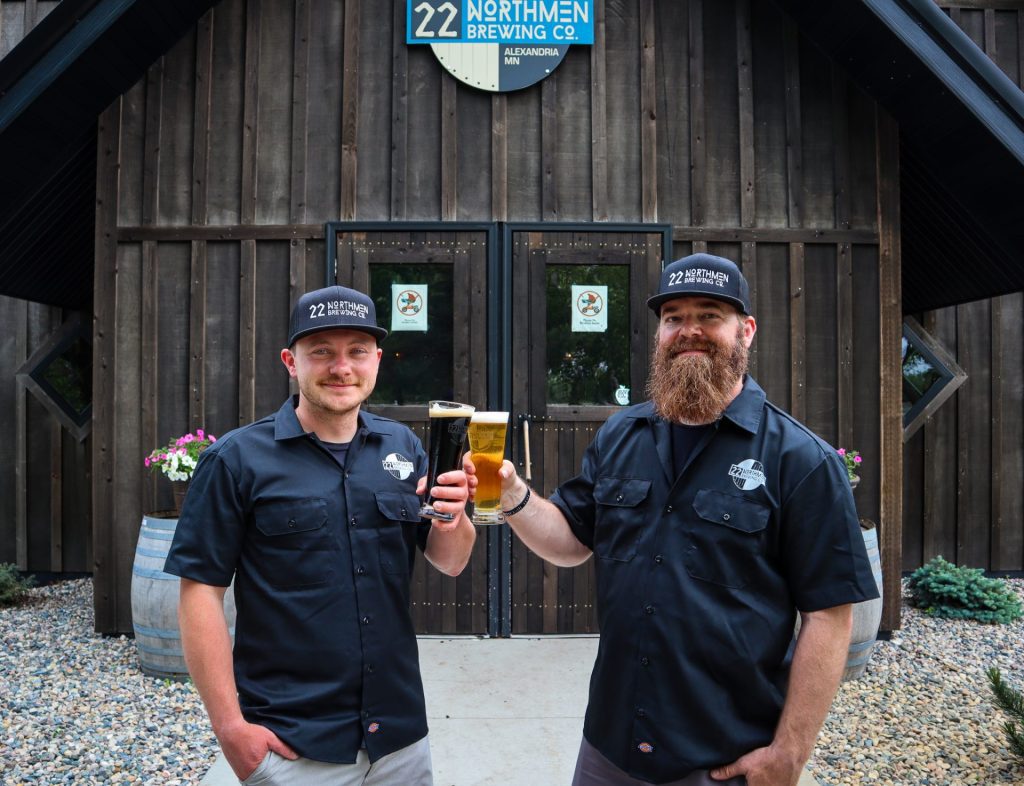 Brewers stand outside brewery